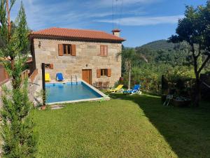 a small house with a swimming pool in the yard at Casa Novelhos in Penafiel