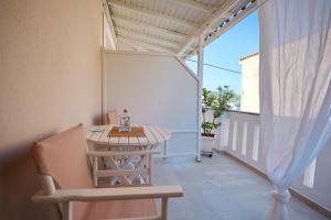 a small balcony with a table and a chair at Ikos Studios and Apartments in Patitiri