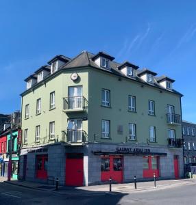 a large green building with red doors on a street at The Galway Rooms in Galway