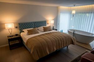 a bedroom with a large bed and a bath tub at Quinta Tapada do Vale in Vila Meã +33 photos