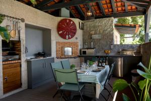 a kitchen with a table with chairs and a clock at Quinta Tapada do Vale in Vila Meã