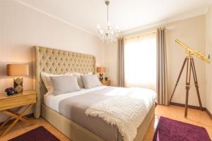 Un dormitorio con una cama grande y una lámpara de araña. en Azor Beach Lodge, en Ponta Delgada