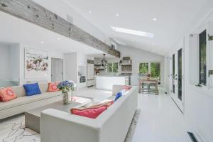 a living room with white furniture and a kitchen at Villa Sapphire Bay in Sag Harbor