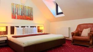 a bedroom with a bed and a chair at Stavilar Hotel - Charming Stay Just Steps Away from Peles Castle in Sinaia in Sinaia +38 photos