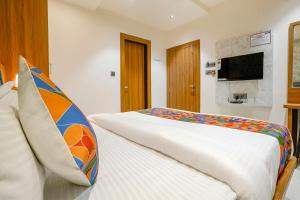 a bedroom with a bed and a tv on the wall at FabHotel Status Residency in Mumbai