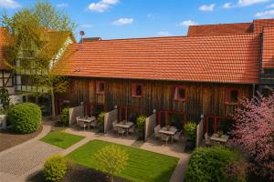a building with a red roof with chairs and a garden at Elementa City Lodge Quedlinburg 5 in Quedlinburg