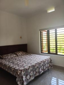 a bedroom with a bed and a large window at Ithal Villa - Home Stay in Wayanad