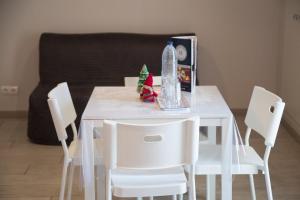 a dining room table with white chairs and a bottle of water at Apartamentos Comfort Calella in Calella