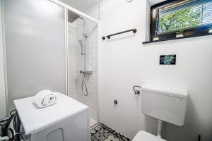 a white bathroom with a shower and a toilet at Vista Apartment With Hot Tub & Large Terrace in Leskovec pri Krškem