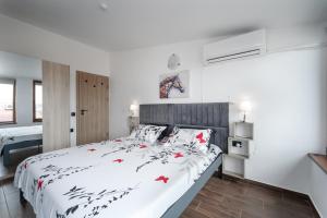 a bedroom with a white bed with red flowers on it at Transilvaniya Apartments in Sozopol
