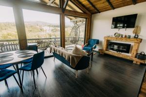 a living room with a table and chairs and a fireplace at Tiny House Todireni in Vatra Dornei