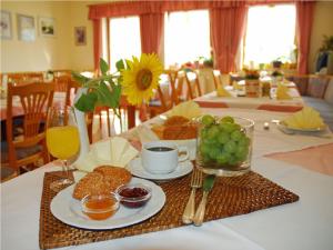 a table with a plate of food and a bowl of fruit at Hotel garni Vogelsang in Bad Füssing