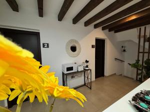a living room with a table and yellow flowers at habitaciones tabarca in Tabarca