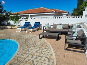 a patio with couches and chairs next to a pool at Villa Milena in Callao Salvaje