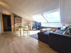 a living room with a couch and a table with chairs at Finn Lodge in Saint-Denis-dʼOléron