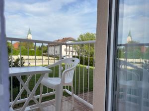 a balcony with a table and a white chair at Hotel Imperium in Moravske-Toplice