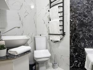 a black and white bathroom with a toilet and a sink at new stail centr in Bălţi