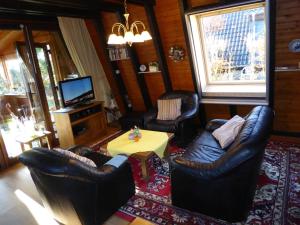 a living room with leather furniture and a television at Eifelwaldhäuschen in Blankenheim +9 photos