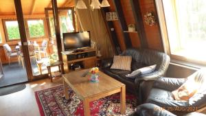 a living room with couches and a table and a television at Eifelwaldhäuschen in Blankenheim