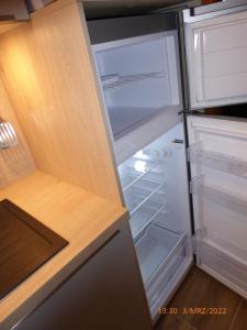 an empty refrigerator with its door open in a kitchen at Eifelwaldhäuschen in Blankenheim