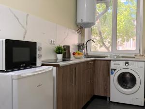 a kitchen with a washing machine and a microwave at new stail centr in Bălţi