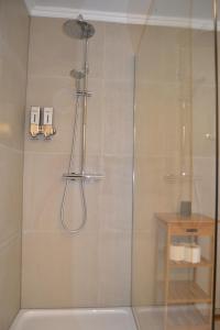 a shower with a glass door in a bathroom at Château d'Harnoy in Yvoir +29 photos