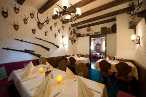 ein Restaurant mit weißen Tischen und Stühlen und Schmetterlingen an der Wand in der Unterkunft Hotel Hasenmayer in Pforzheim
