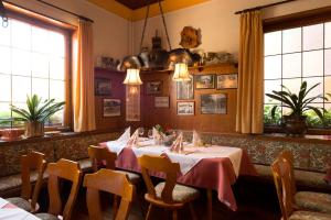 ein Esszimmer mit Tischen, Stühlen und Fenstern in der Unterkunft Hotel Hasenmayer in Pforzheim
