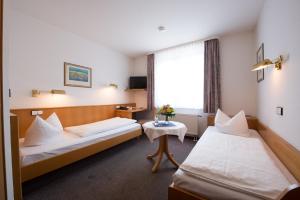 ein Hotelzimmer mit zwei Betten und einem Fenster in der Unterkunft Hotel Hasenmayer in Pforzheim