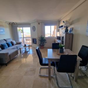 a living room with a couch and a table and chairs at The Gaff in the Sun in Manilva