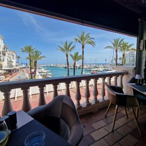 a balcony with a view of the water and palm trees at The Gaff in the Sun in Manilva