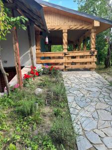 a wooden pavilion with flowers in front of a house at Acasa la Coana Mare in Bălăneşti