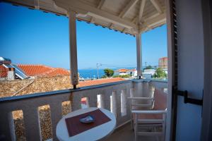 a view from the balcony of a house with a table and chairs at Ikos Studios and Apartments in Patitiri