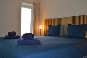 a large bed with blue sheets and blue pillows at Château d'Harnoy in Yvoir