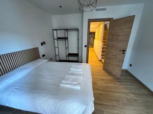 a bedroom with a large white bed with towels on it at Casa Ara Montanejos in Montanejos
