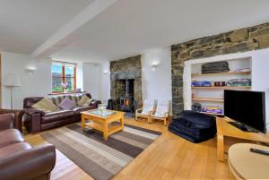 a living room with a couch and a tv at Finest Retreats - Gladstone in Aberdaron