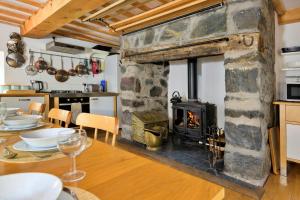 a kitchen and dining room with a stone fireplace at Finest Retreats - Gladstone in Aberdaron
