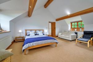 a large bedroom with a bed and a couch at Finest Retreats - Gladstone in Aberdaron