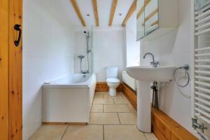 a bathroom with a sink and a tub and a toilet at Finest Retreats - Gladstone in Aberdaron +29 photos