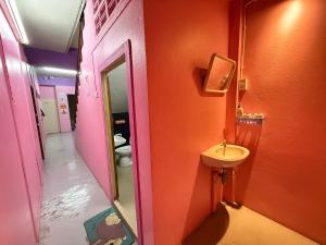 a bathroom with a sink and an orange wall at Madam Guesthouse in Krabi +65 photos