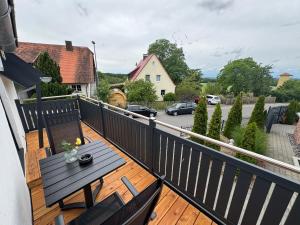 a wooden deck with a table on a balcony at Steigerwald Habitat in Oberschwarzach