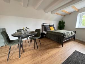 a bedroom with a bed and a table and chairs at Steigerwald Habitat in Oberschwarzach