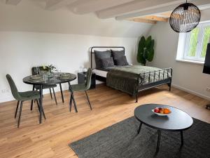 a living room with a bed and two tables and chairs at Steigerwald Habitat in Oberschwarzach