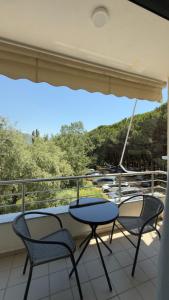 a table and chairs on a balcony with a boat at Viluni Coast Apartment in Velipojë