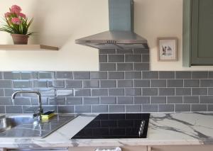 a kitchen with blue tile on the wall and a sink at Foxglove House in Douglas +94 photos