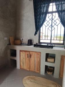a kitchen with a counter and a window at Ubuntu Home in Mto wa Mbu +22 photos