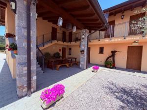 an outdoor patio with pink flowers in a building at Agriturismo e Alloggi Luis Gianni in Cividale del Friuli