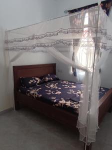 a bedroom with a bed with a canopy at Ubuntu Home in Mto wa Mbu