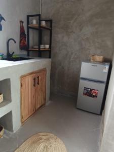 a kitchen with a sink and a refrigerator at Ubuntu Home in Mto wa Mbu