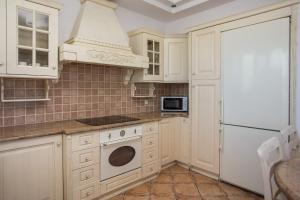 a kitchen with white cabinets and a stove top oven at Villa Kallithea Sunrise in Koskinou